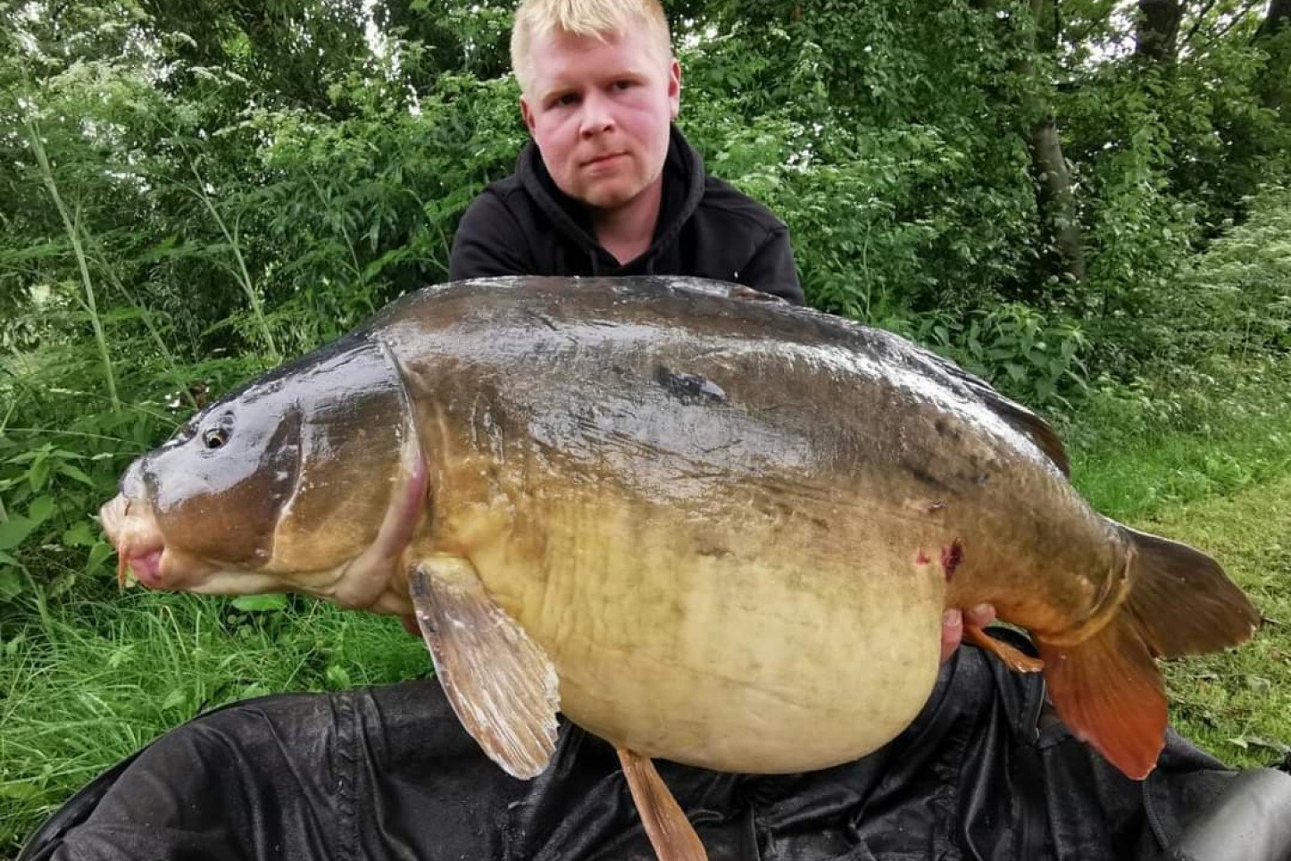 Andreas Hauke von Bait Perfection mit großem Spiegelkarpfen.