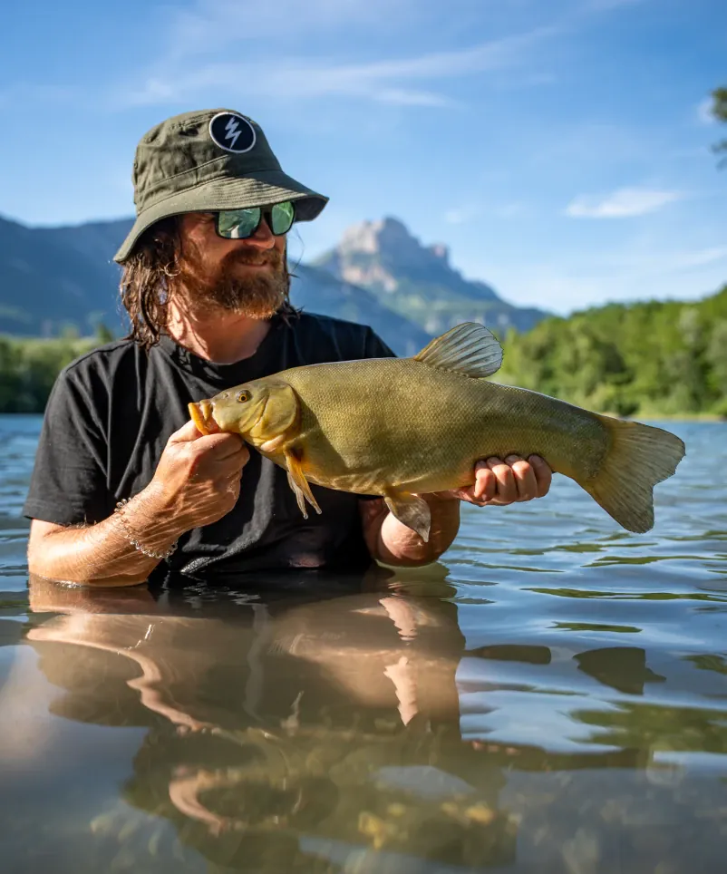 Mark Dörner fängt Schleie vor Alpenpanorama.