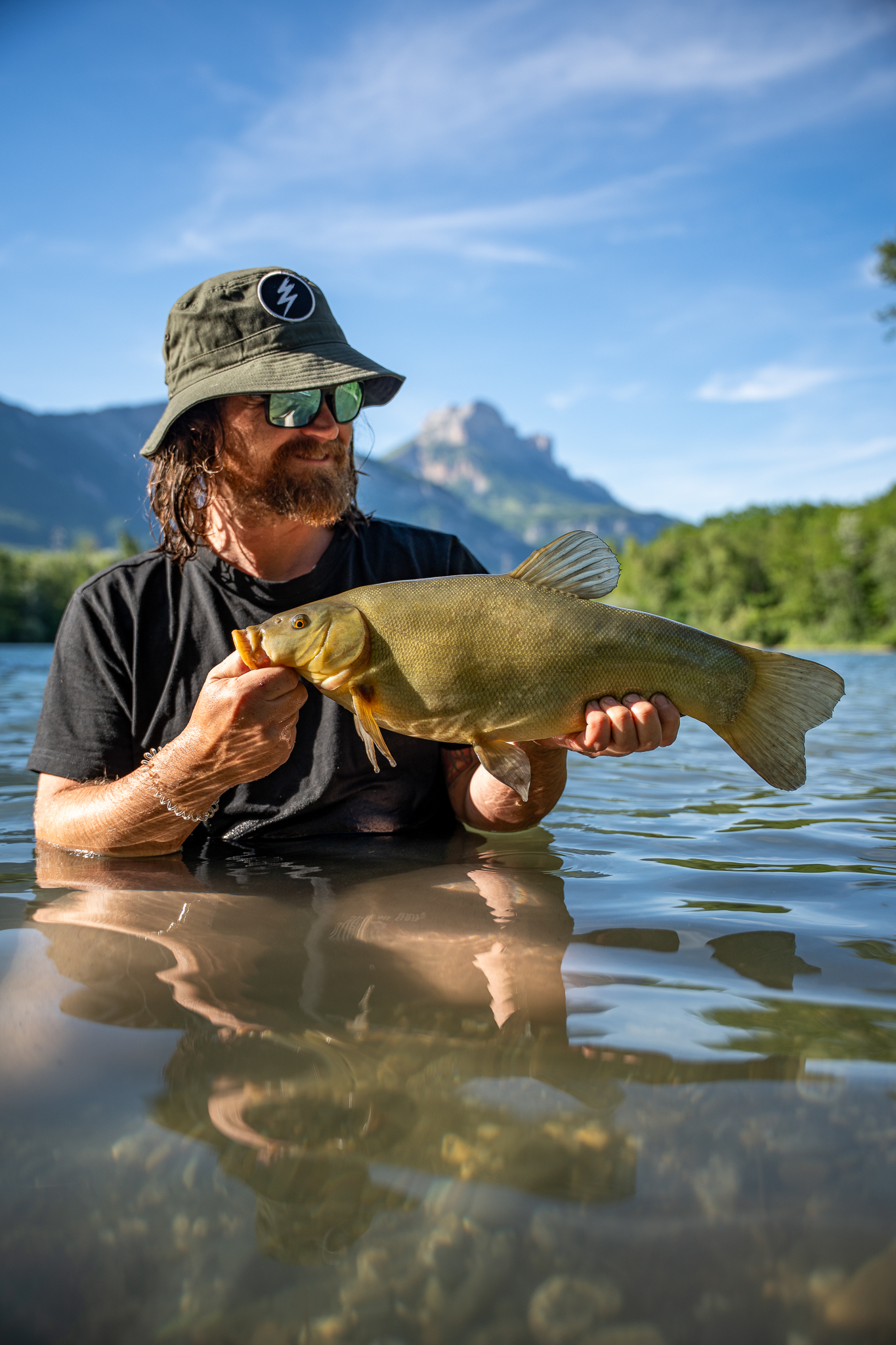 Mark Dörner fängt Schleie vor Alpenpanorama.