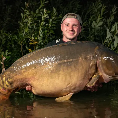 Angler mit riesigem Spiegelkarpfen