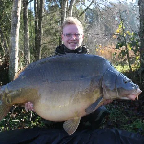 Angler mit riesigem Spiegelkarpfen