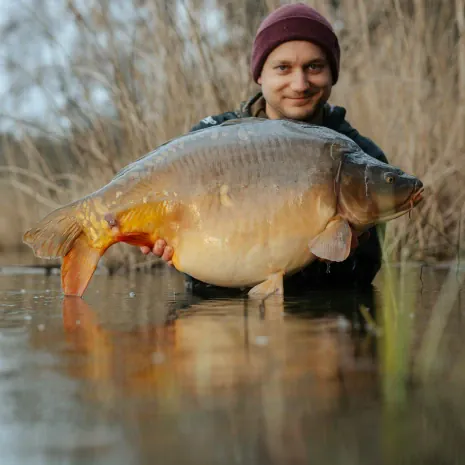 Angler mit kleinem Karpfen